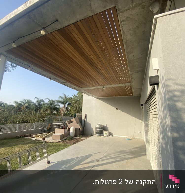 תקרה מעץ עם תאורה תלויה בחצר